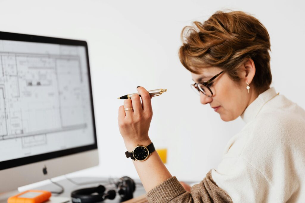 pexels-photo-4491451-4491451 Confident businesswoman using computer for architectural analysis in a modern office.